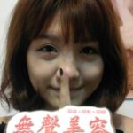 顧客合照,手指比出「噓」的手勢並拿著「無聲美容」標語牌,象徵品牌理念中的「不推銷、不誇張、不話術」